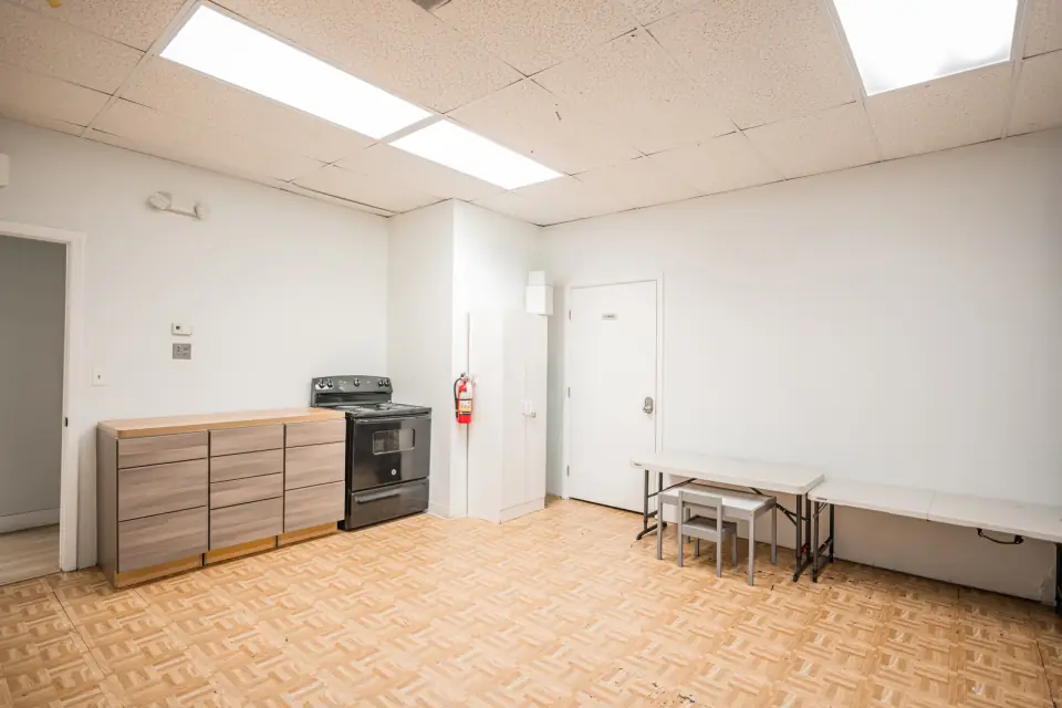 The Sacred Farewells serving kitchen with counters, a stove and a serving table ready